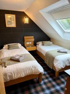 a attic room with two beds and a skylight at Misty Isle Apartments Ltd - Maol View in Kyleakin