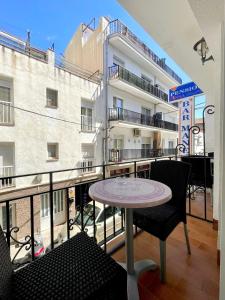 a balcony with a table and chairs and a building at Pensió Anna in Tossa de Mar