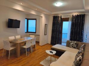 a living room with a couch and a dining room at Talia apartments & pool in Dobra Voda