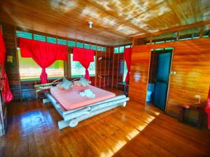 a bedroom with a bed in a room with red curtains at Amazon Oasis Floating Lodge in Iquitos +35 photos