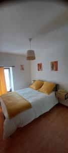 a bedroom with a large white bed with yellow pillows at L'auberge du Houx in La Houssière