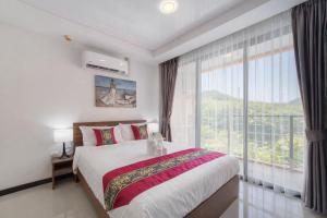 a bedroom with a bed and a large window at MIRA Condo 1BR Pool View NBC Nai Harn in Nai Harn Beach
