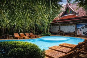 a swimming pool with chairs and a palm tree at MIRA Condo 1BR Pool View NBC Nai Harn in Nai Harn Beach