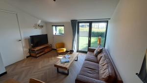 a living room with a couch and a tv at De Platwever 3C in Zelhem