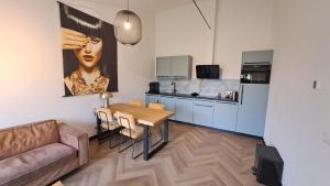 a living room with a couch and a table and a kitchen at De Platwever 3C in Zelhem