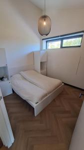 a bedroom with a bed and a window at De Platwever 3C in Zelhem