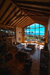 a large living room with couches and a large window at Blanca Patagonia Hostería Boutique y Cabañas in El Calafate
