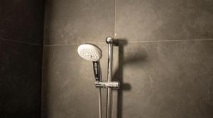 a shower with a shower head in a bathroom at City Apartment - Perfect for two in Tåstrup