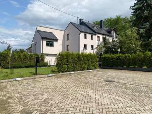 a house with a brick driveway in front of a house at Sonnenlay Lounge Ferienhaus und Studio Balkon Garten E-Ladestation in Brauneberg