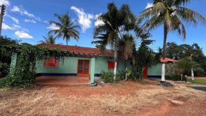 a house with palm trees in front of it at A área Orioli in Jardinópolis