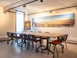 a table and chairs in a room with a painting on the wall at Ibis Marseille Marignane Technopole in Marignane