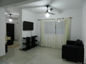 - un salon avec une télévision et un canapé dans l'établissement Residencial Vista Del Bosque, à Santiago de los Caballeros