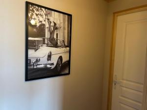 a picture of a white car hanging on a wall at Sam Va in Dolus-d'Oléron +3 photos