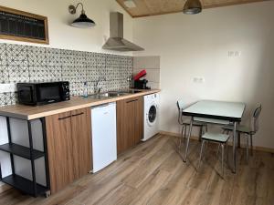 a kitchen with a sink and a table with a microwave at Sam Va in Dolus-d'Oléron