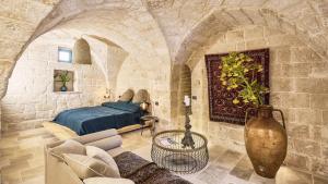a bedroom with a bed in a stone wall at Bambarone L'Agriturismo in Fasano