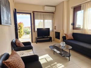 a living room with two couches and a tv at Lela's House in Yerakiní