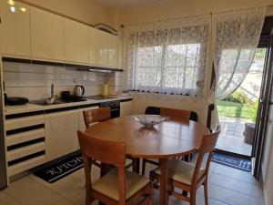 a kitchen with a wooden table and a table and chairs at Lela's House in Yerakiní