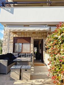 a patio with couches and a table in front of a building at Lela's House in Yerakiní