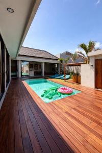 a house with a swimming pool on a wooden deck at Villa Donald in Canggu