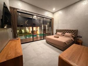 a bedroom with a bed and a large window at Villa Donald in Canggu +17 photos