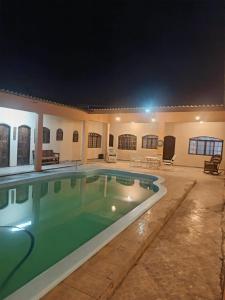 a swimming pool in a villa at night at Pousada e hostel Braga in Itanhaém