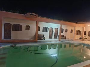 a swimming pool in a house at night at Pousada e hostel Braga in Itanhaém