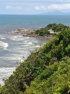 a view of a beach with people in the water at Pousada e hostel Braga in Itanhaém