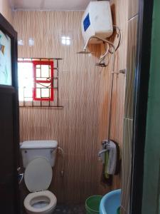 a bathroom with a toilet and a sink and a window at July 16th hotel and event centre in Alagbado
