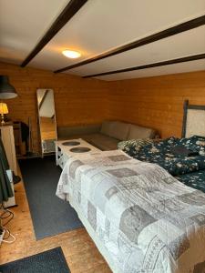 a bedroom with two beds and a couch at Tiny house Söderåsen in Ljungbyhed