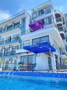a hotel with a swimming pool and a blue umbrella at Time Villa in Tam Ðảo