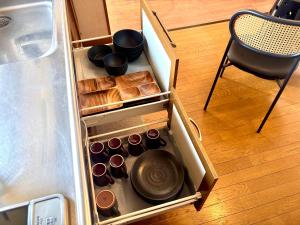 an open drawer of a refrigerator with pans and utensils at Snoa Kitanomine - スノア キタノミネ - in Furano +71 photos