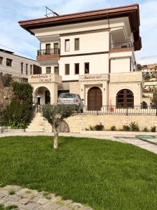 a building with a car parked in front of it at Hotel Rezidenca Desaret in Berat