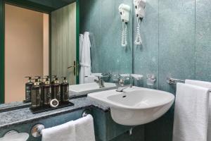 ein Badezimmer mit Waschbecken und Spiegel in der Unterkunft Executive Hotel Evolution - Spiaggia Inclusa in Cesenatico + 37 Fotos