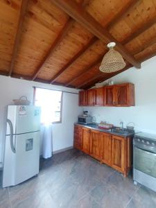 a kitchen with wooden cabinets and a white refrigerator at Villa Belén in Guarne