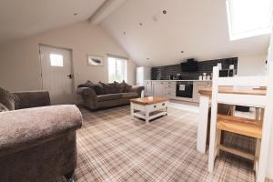 a living room with a couch and a table at Barneys cottage with hot tub in the Lake District National Park in Lake District National Park