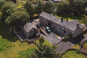 an old house with a car parked in front of it at Barneys cottage with hot tub in the Lake District National Park in Lake District National Park
