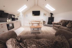 a living room with two couches and a table at Barneys cottage with hot tub in the Lake District National Park in Lake District National Park +19 photos