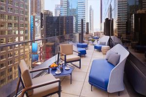 a balcony with chairs and tables on a building at Hard Rock Hotel New York - Partner of ALL Accor in New York