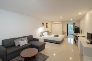 a living room with a couch and a bed at Elegant Modern White Suite in Chiang Mai