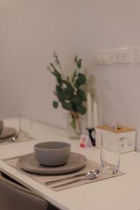 a bowl on a plate on a counter with a glass at Elegant Modern White Suite in Chiang Mai