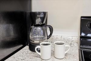 a blender sitting on a counter with two coffee cups at Working 9 to Pine by Beyond Expectations with Views in Sevierville +19 photos