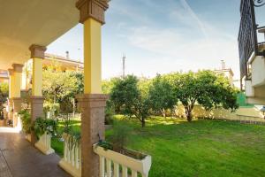 a porch with a white fence and a green yard at Mary s House Cerveteri Wifi AC in Cerveteri