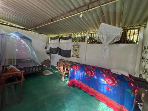 a room with a bed and a table and chairs at Jungle Room in Talalla South