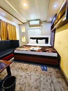 a bedroom with a bed and a couch at Hotel O Royal in kolkata