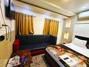 a bedroom with a bed and a couch and a table at Hotel O Royal in kolkata