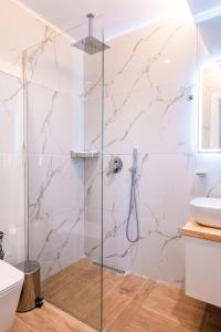 a bathroom with a glass shower with a sink at Velora Apartments Ksamil in Ksamil +33 photos