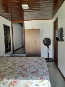 a bedroom with a bed and a fan at Kitnet Praia do Porto in Imbituba