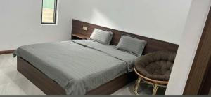 a bedroom with a large bed and a chair at Grace hotel - dakmil in Bon Sar Pa