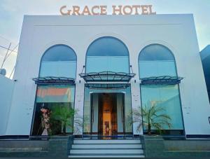 a large white building with a gate hotel at Grace hotel - dakmil in Bon Sar Pa