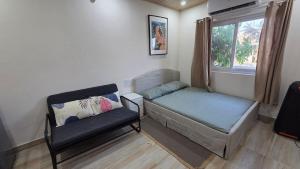 a small room with a bed and a chair at Rewind by NestoraHomes in Jadgenhalli +87 photos